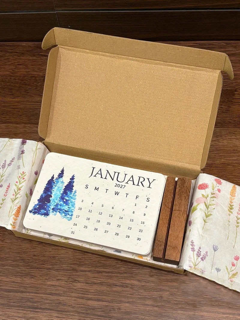 Open gift-style box with 2027 seed calendar cards and a wooden display holder pictured