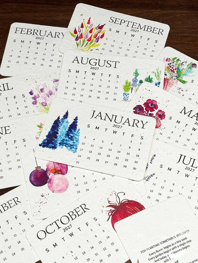 Close-up of colorful botanical and seasonal designs on 2027 calendar cards