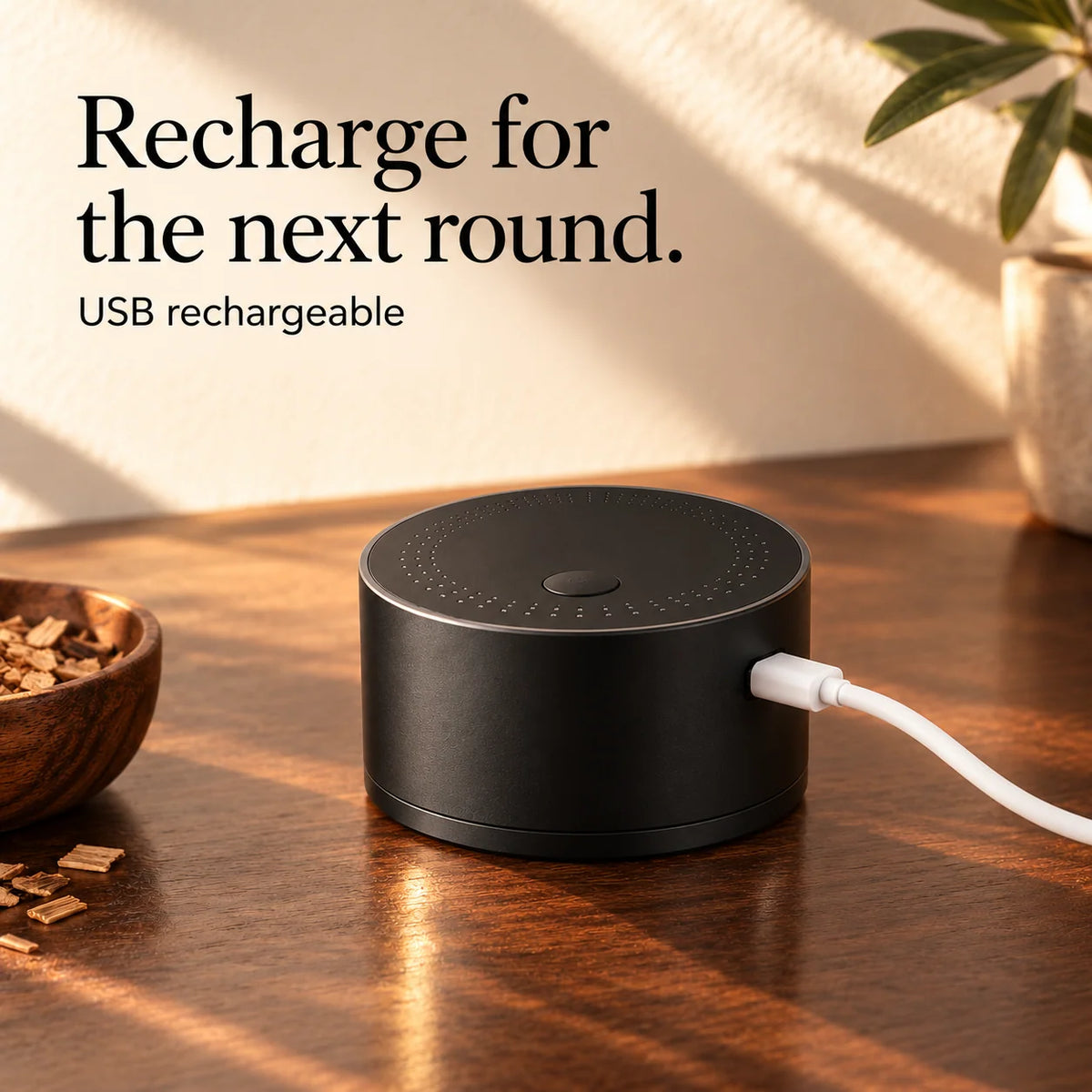 Rechargeable black electric whiskey smoker connected to a USB charging cable
